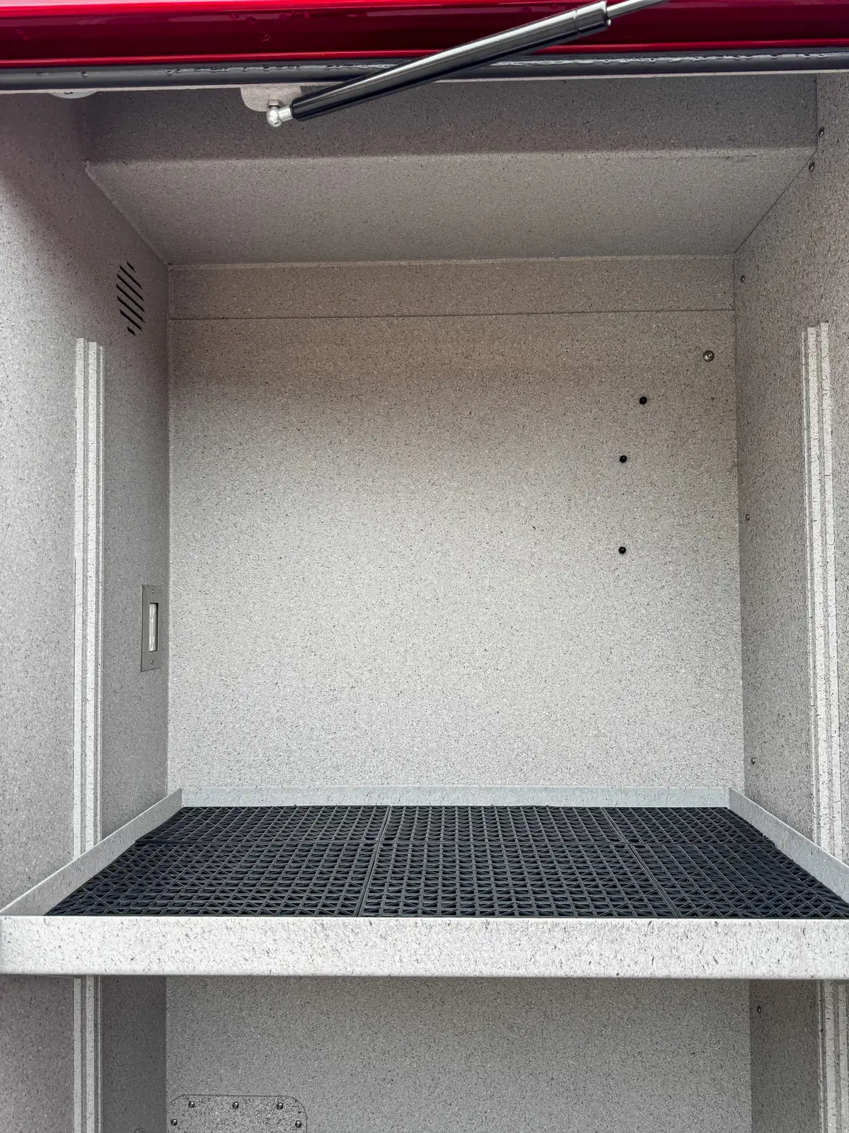 Compartment interior close-up with side wall, shelf, and track system.